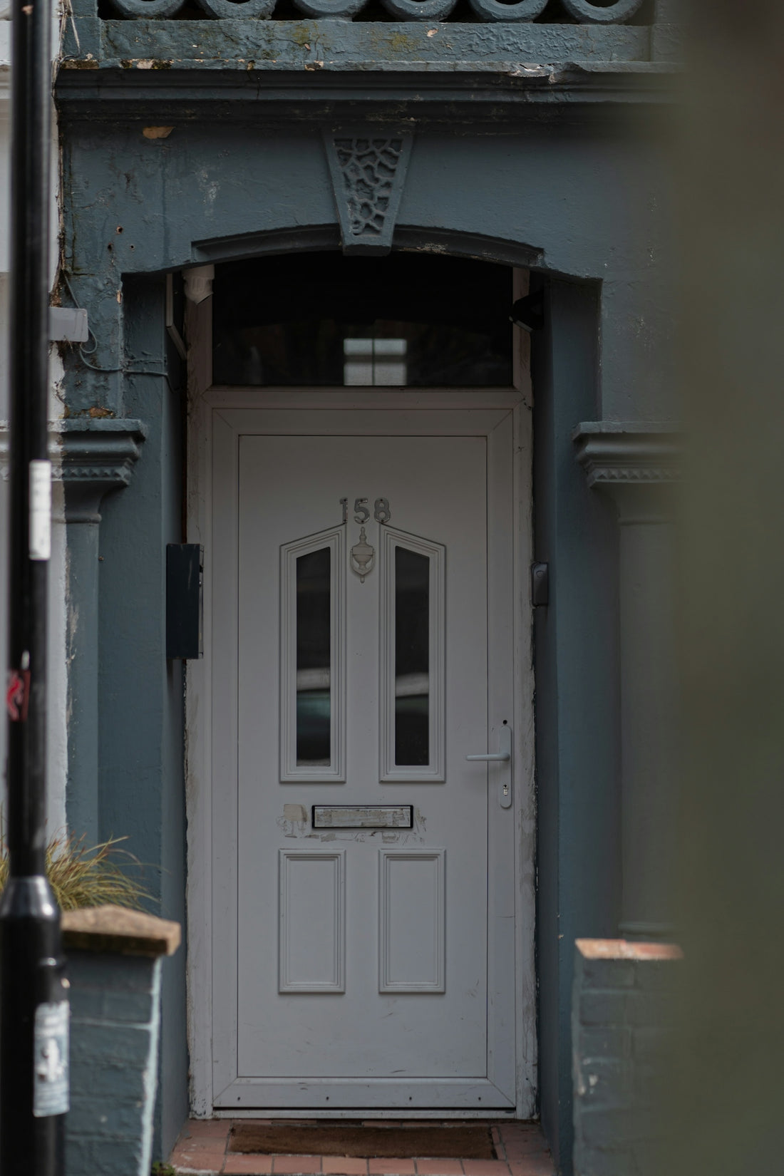 a white front door on a blue building