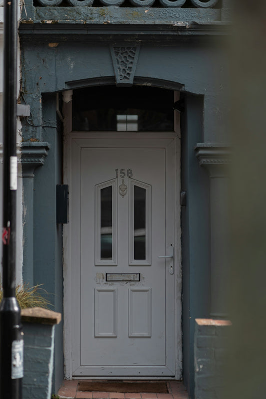 a white front door on a blue building