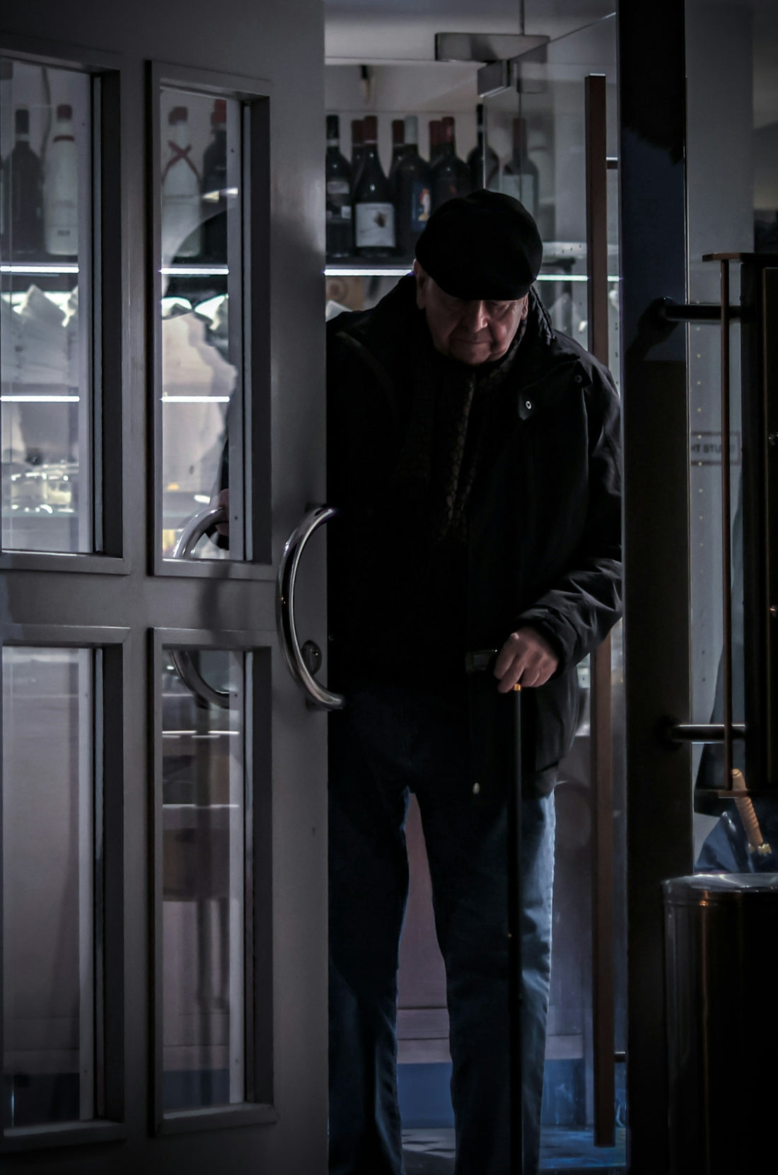 a man standing in a doorway with a cane