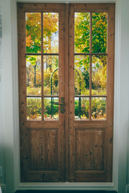 A pair of wooden doors sitting inside of a room
