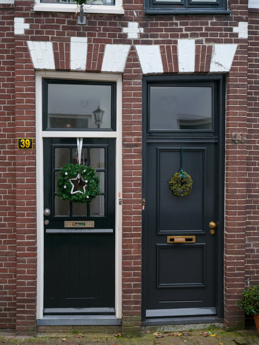 A black front door with a wreath on it
