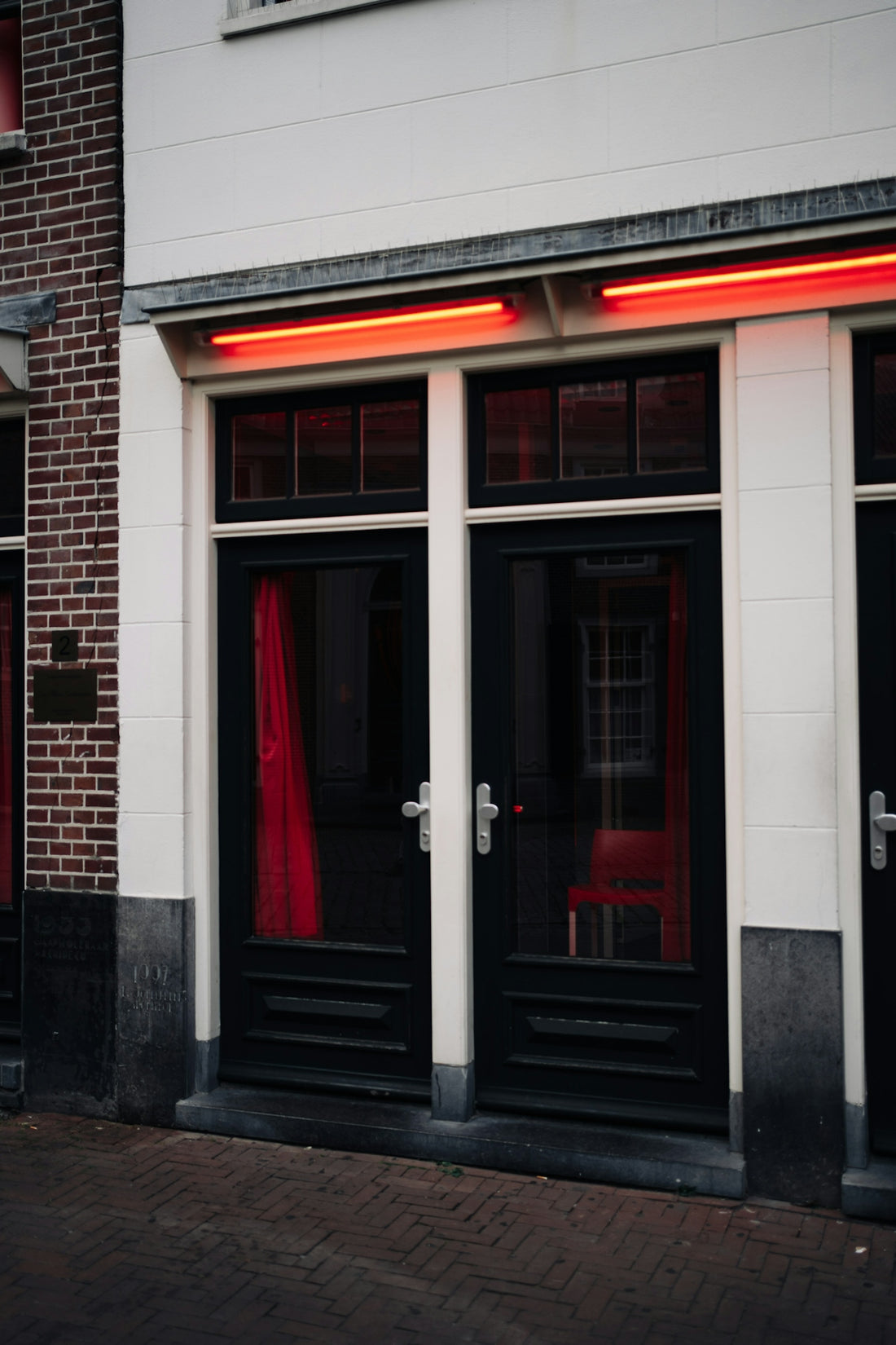 Double doors with red curtains and neon lights.