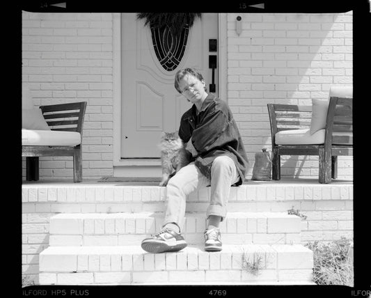 Man and cat sitting on porch steps