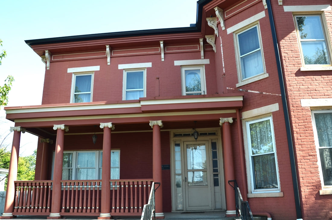 A red victorian house with a porch