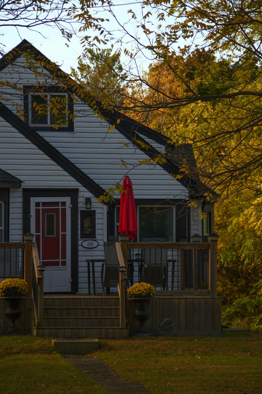 White house with red door and autumn trees