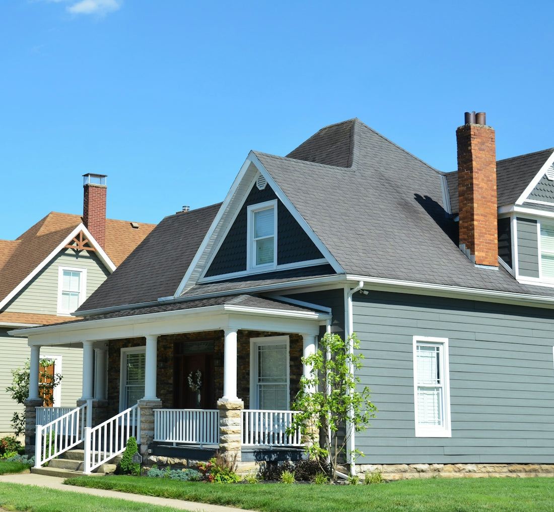 A blue house with a white porch and red chimney.