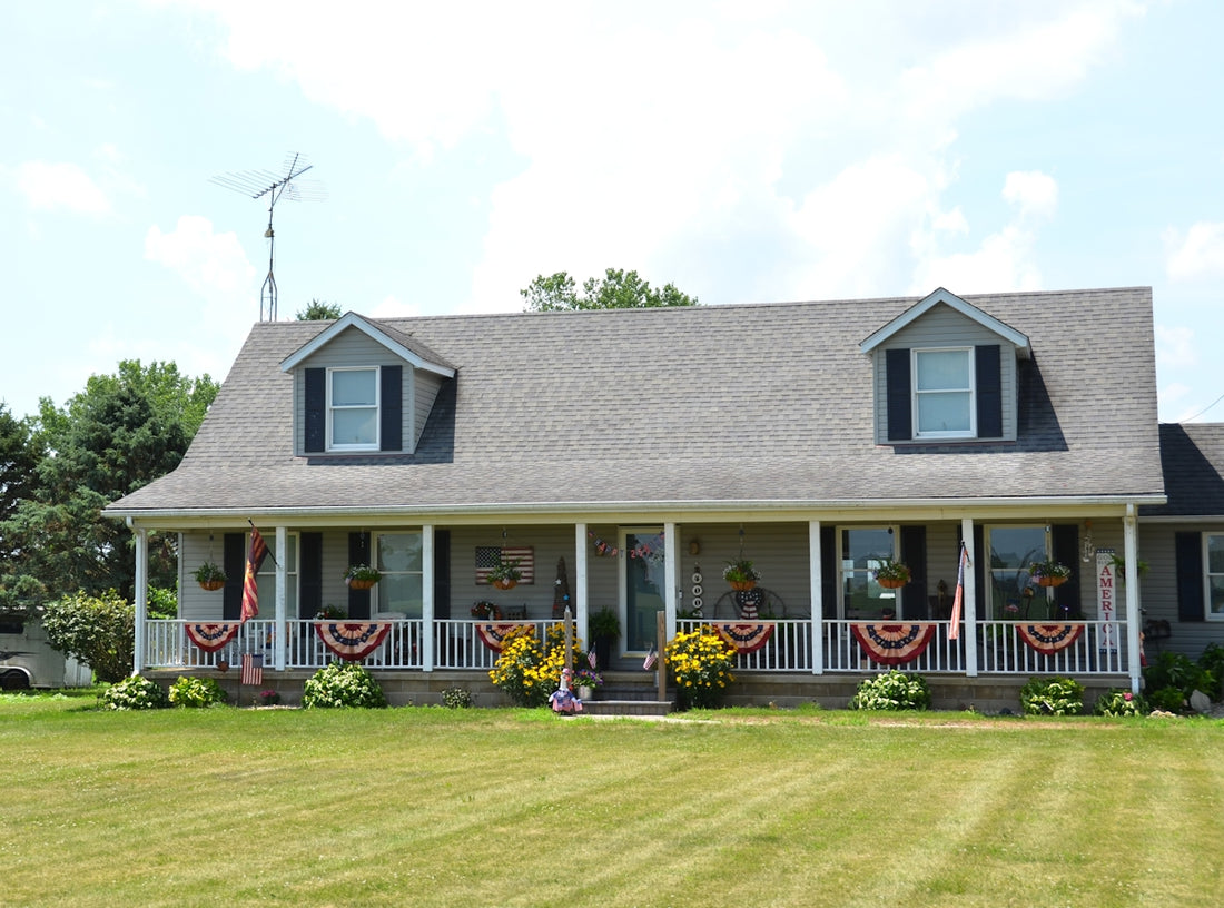 A two-story house with a porch and patriotic decorations.