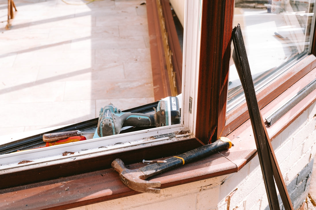 Hammer and drill on window sill during repair