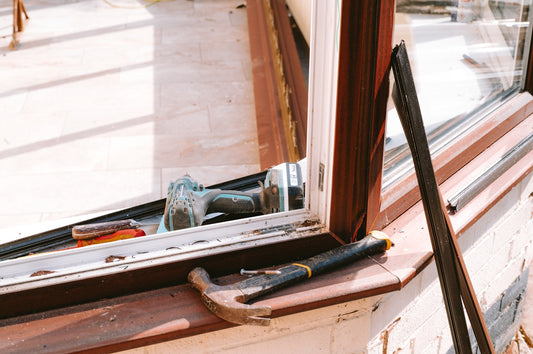 Hammer and drill on window sill during repair