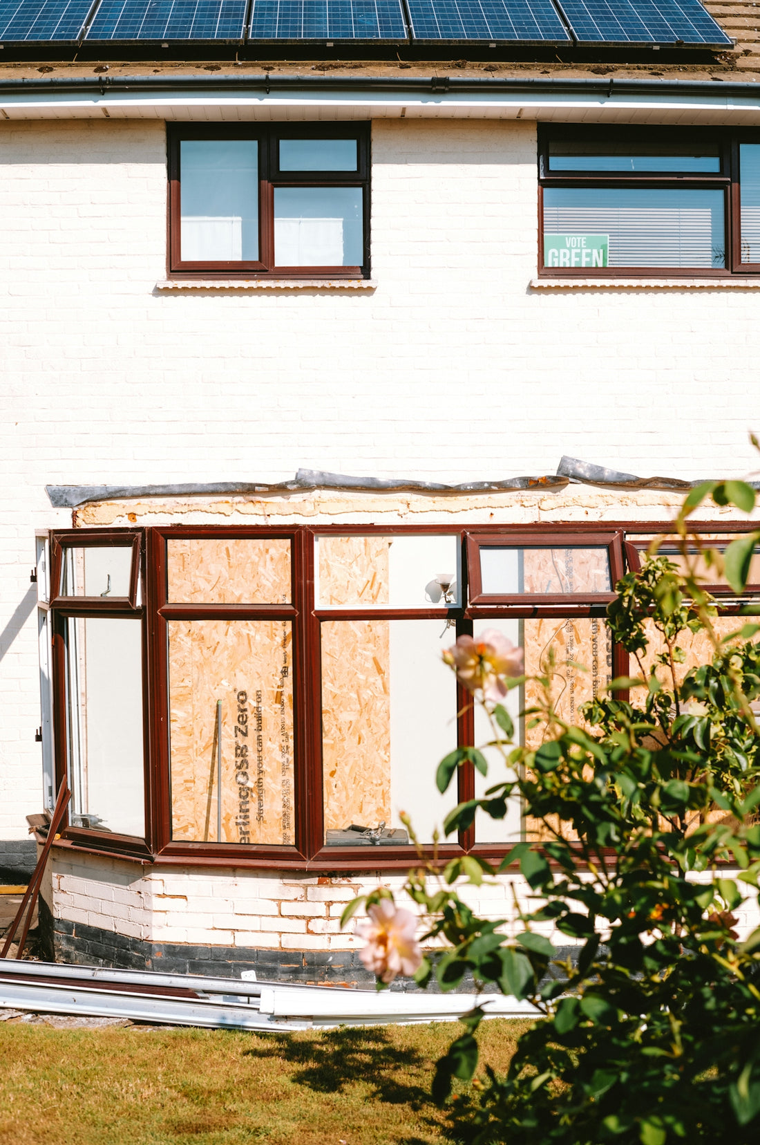 House with boarded-up conservatory and solar panels